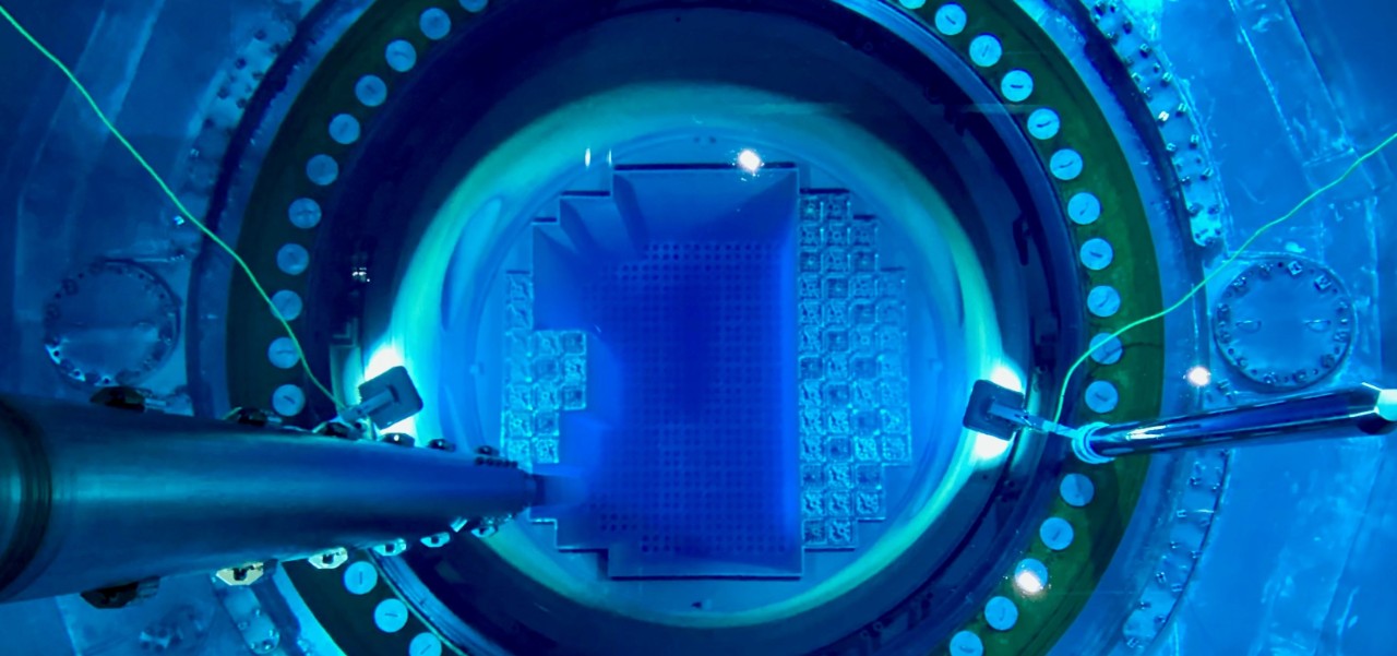 View inside a Southern Nuclear reactor core glowing with blue Cherenkov radiation, showing fuel rods submerged under water during operation.