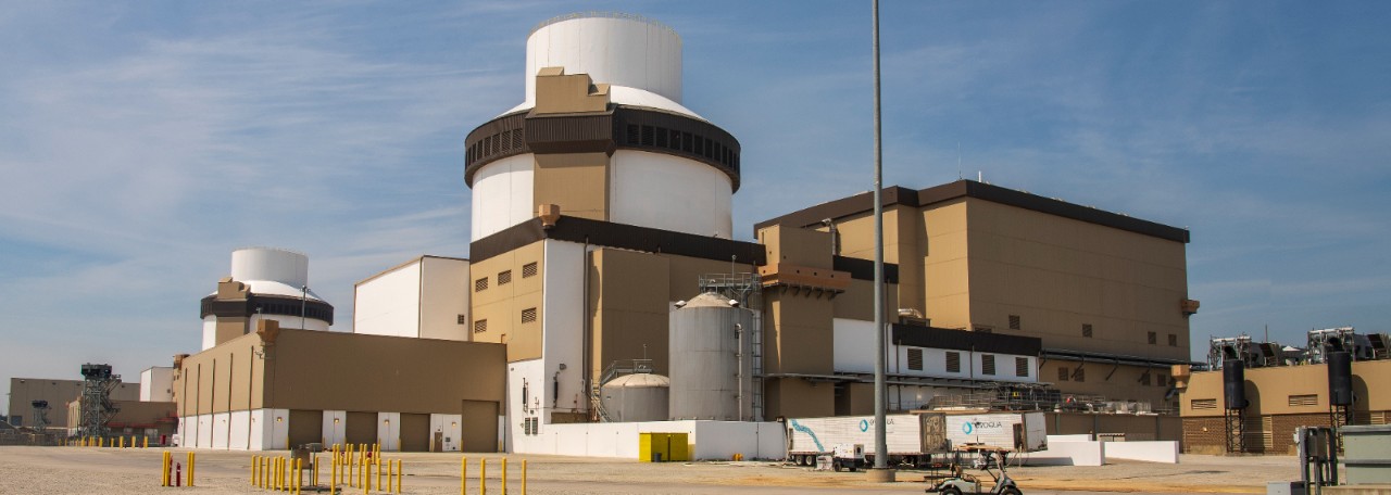 Wide shot of a Southern Nuclear facility with advanced reactor structures, featuring clean lines, cylindrical containment, and clear skies.