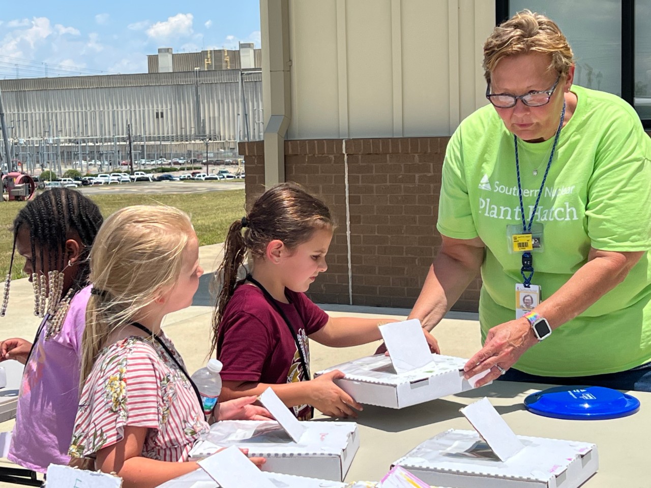 Southern Nuclear employee at Plant Hatch guides young students through a hands-on activity, fostering STEM interest in the nuclear community.