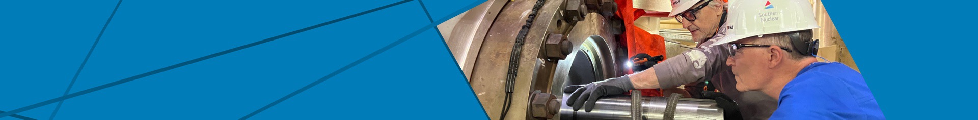 Southern Nuclear leadership team members inspect turbine equipment closely, demonstrating hands-on guidance and technical expertise in action.