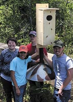 Eagle Scout candidate Will Smith with Scouts from Troop 106 pose with a newly installed wood duck nesting box at Plant Farley.