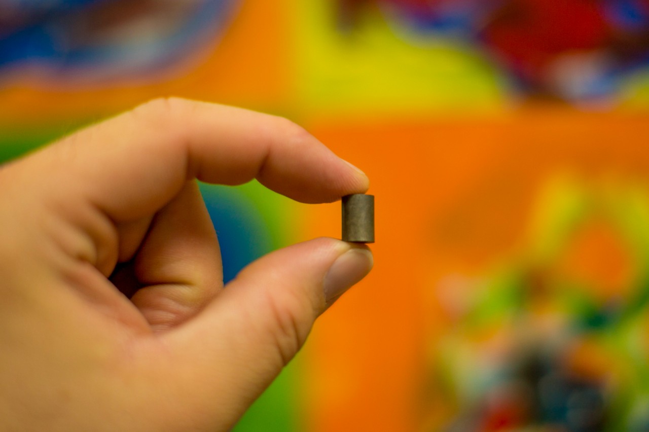 A hand holds a single uranium fuel pellet, illustrating the concentrated energy source used in Alabama and Georgia nuclear power plants.