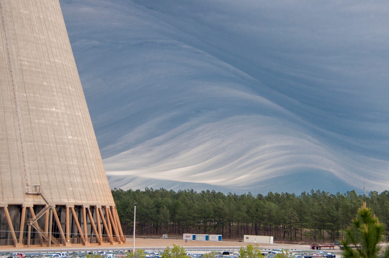 A cooling tower at Vogtle nuclear power plant in Georgia rises against dramatic, cloud-filled skies.