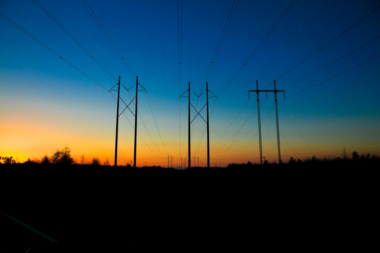 Transmission lines stretch across the horizon at sunset, symbolizing energy distribution from nuclear power plants in Alabama and Georgia.
