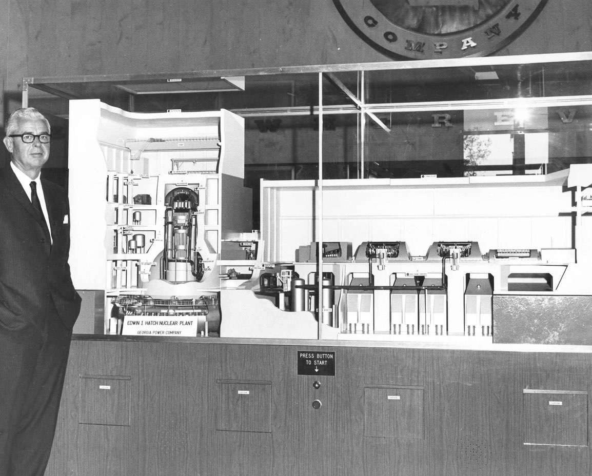 Edwin I. Hatch standing next to the original plant model