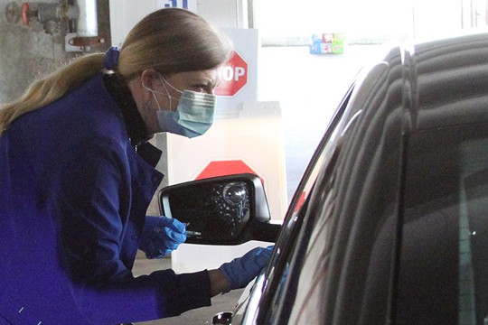 Nurse speaking to patient through car window