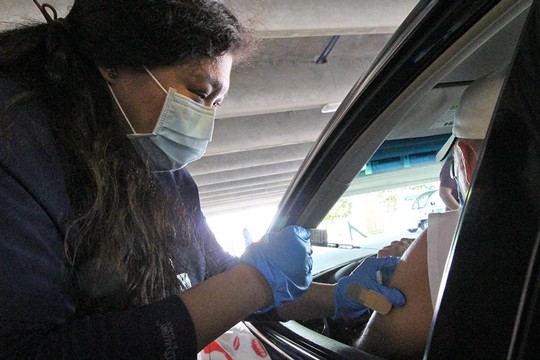 Nurse administering vaccine into Patient's shoulder